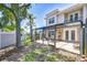 Exterior view of a two-story home with a screened patio and well-maintained backyard with a privacy wall at 1411 Tessano Pl, Palm Harbor, FL 34683