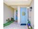 Double doorway entrance, featuring a colorful sunflower wreath on the main door and potted plants at 1411 Tessano Pl, Palm Harbor, FL 34683