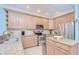 Close-up of the kitchen featuring stainless steel appliances, light wood cabinetry, and granite countertops at 1411 Tessano Pl, Palm Harbor, FL 34683