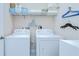 Convenient laundry room featuring a washer, dryer, and wire shelving for efficient storage of household items at 1411 Tessano Pl, Palm Harbor, FL 34683