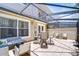 Inviting covered patio featuring tiled flooring, comfortable seating, and a cozy fire pit for outdoor enjoyment at 1411 Tessano Pl, Palm Harbor, FL 34683