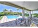 Inviting poolside patio with shaded seating, perfect for relaxing by the sparkling community pool and lush landscape at 1411 Tessano Pl, Palm Harbor, FL 34683