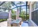 Relaxing screened patio featuring a cozy seating area with plush cushions and a stylish fire pit table at 1411 Tessano Pl, Palm Harbor, FL 34683