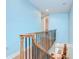 Bright stairway showcasing wood floors, a wrought iron railing, and vibrant blue walls leading to the home's entrance at 1411 Tessano Pl, Palm Harbor, FL 34683