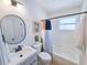 Bright bathroom featuring a white vanity, round mirror, and a tub with a colorful shower curtain at 1416 55Th N Ave, St Petersburg, FL 33703