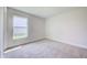 This bedroom features neutral carpet and a window with a view to the neighborhood at 16433 66Th E Ln, Parrish, FL 34219