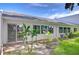 Backyard of house featuring a small patio area, tropical landscaping, and blue skies at 1655 S Highland Ave # B118, Clearwater, FL 33756