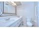 Bright bathroom features a white vanity, decorative mirror, and a tile floor at 1655 S Highland Ave # B118, Clearwater, FL 33756
