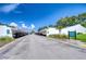 View of well maintained community with lush landscaping and covered parking under a sunny sky at 1655 S Highland Ave # B118, Clearwater, FL 33756