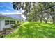 Exterior of the house with a large, grassy yard and mature shade trees at 1655 S Highland Ave # B118, Clearwater, FL 33756