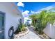 Condo exterior with a blue umbrella, lush tropical plants, and walkway at 1655 S Highland Ave # B118, Clearwater, FL 33756