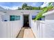 Inviting condo exterior with white fence, walkway, and lush tropical landscaping at 1655 S Highland Ave # B118, Clearwater, FL 33756