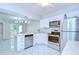 Open kitchen featuring stainless steel appliances, white cabinets, and tile flooring at 1655 S Highland Ave # B118, Clearwater, FL 33756