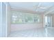 Bright sunroom with multiple windows, white tile floors, and access to the exterior at 1655 S Highland Ave # B118, Clearwater, FL 33756