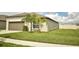 Single-story beige home with a two-car garage, a manicured lawn, and sidewalk at 16623 Carlton Pond St, Wimauma, FL 33598