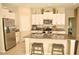 Well-equipped kitchen featuring stainless steel appliances, granite countertops, and a center island with seating at 16623 Carlton Pond St, Wimauma, FL 33598