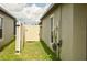 The side yard of this home has vinyl fence, a gate, and utility connections at 16623 Carlton Pond St, Wimauma, FL 33598