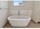 Bright bathtub alcove featuring a standalone soaking tub, tile backsplash, and chrome hardware at 199 Dali Blvd # 607, St Petersburg, FL 33701