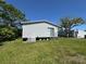 Exterior view of the rear of the home with sliding glass door and green lawn at 205 Portia S St, Nokomis, FL 34275