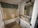 Bathroom featuring an older bathtub with shower curtain, mirror, sink, and stained toilet at 205 Portia S St, Nokomis, FL 34275