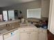 Cozy kitchen featuring a dual basin sink, light beige countertops and shaker style cabinets at 205 Portia S St, Nokomis, FL 34275