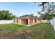 Backyard view showcasing the home's exterior, a fenced yard, and lush greenery at 212 W Humphrey St, Tampa, FL 33604