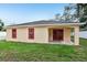 Exterior view of home featuring a charming patio and bright red window trim at 212 W Humphrey St, Tampa, FL 33604