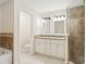 Bathroom featuring double sink vanity, tiled walk-in shower, and commode at 212 W Humphrey St, Tampa, FL 33604
