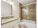 Bathroom featuring a granite countertop vanity and a shower-over-tub with glass doors and tiled walls at 212 W Humphrey St, Tampa, FL 33604