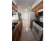 Galley kitchen with tile floor, white appliances, and brown cabinets opens to the living area at 226 Thorn Tree Pl # 226, Brandon, FL 33510