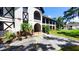 Accessible condo entrance with a ramp, showcasing charming Tudor-style architecture and landscaping at 230 N Bayshore Blvd # 103, Clearwater, FL 33759
