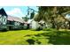 Striking view of Tudor-style condos surrounded by mature trees and a vibrant green lawn at 230 N Bayshore Blvd # 103, Clearwater, FL 33759