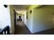 Bright condo hallway with exterior wall texture and sconce lighting leading to unit entry doors at 230 N Bayshore Blvd # 103, Clearwater, FL 33759