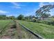 Large backyard with chainlink fence and view of surrounding neighborhood and blue skies above at 2419 Wishing Well Way, Tampa, FL 33619