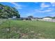 Expansive backyard with a full perimeter fence, showcasing the home's exterior and lawn at 2419 Wishing Well Way, Tampa, FL 33619