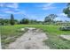 Large backyard view showing fence, picnic table, grass and surrounding trees on a sunny day at 2419 Wishing Well Way, Tampa, FL 33619