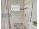 Tiled shower with window and mosaic shower floor at 2419 Wishing Well Way, Tampa, FL 33619