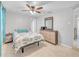 Bedroom with a ceiling fan and dresser, featuring a tile floor and bright window at 2419 Wishing Well Way, Tampa, FL 33619