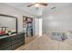 Bedroom featuring ceiling fan, black dresser with mirror, and closet with storage containers at 2419 Wishing Well Way, Tampa, FL 33619