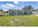 Charming single-story home with a well-maintained lawn and a striking red front door at 2419 Wishing Well Way, Tampa, FL 33619