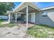 Covered patio area featuring sliding doors, grey brick siding, and adjacent screened in porch at 2419 Wishing Well Way, Tampa, FL 33619