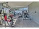 Covered patio used as a gym featuring a variety of fitness equipment on a neutral colored concrete floor at 2419 Wishing Well Way, Tampa, FL 33619