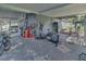 Enclosed patio featuring fitness equipment, paint supplies, storage shelves and a concrete floor at 2419 Wishing Well Way, Tampa, FL 33619