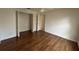 Empty bedroom with wood floors, a ceiling fan, and access to the closet and bathroom at 2635 Jarvis Cir, Palm Harbor, FL 34683