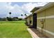 Lush backyard with manicured lawn, complemented by tropical palms and a brick pathway, leading to a serene setting at 29435 Snap Hook Dr, San Antonio, FL 33576