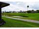 Expansive backyard view showcasing a tranquil canal, lush green grass, and neighboring houses at 29435 Snap Hook Dr, San Antonio, FL 33576