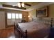 Bedroom features hardwood floors, tray ceiling, ceiling fan and shuttered windows at 29435 Snap Hook Dr, San Antonio, FL 33576