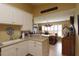 Well-lit kitchen with white cabinetry, stone countertops, and a view of the cozy dining area at 29435 Snap Hook Dr, San Antonio, FL 33576
