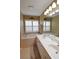 Relaxing main bathroom with dual sinks and a soaking tub under shuttered windows at 29435 Snap Hook Dr, San Antonio, FL 33576