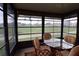 Relaxing sunroom with a glass-top table, cushioned chairs, and expansive windows providing scenic views at 29435 Snap Hook Dr, San Antonio, FL 33576